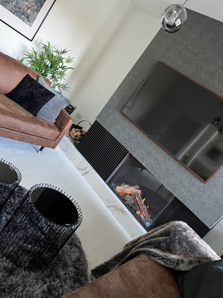 Esempio di un soggiorno minimal con camino ad angolo e TV a parete