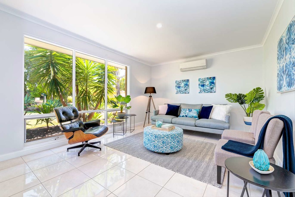 This is an example of a beach style living room in Adelaide with white walls and white floor.