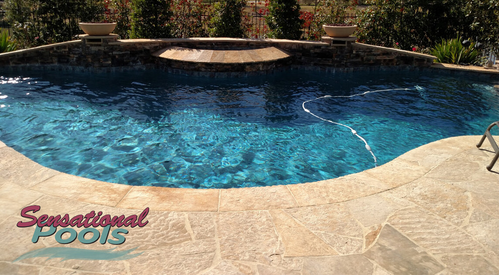 Example of a large tuscan backyard concrete and custom-shaped natural pool fountain design