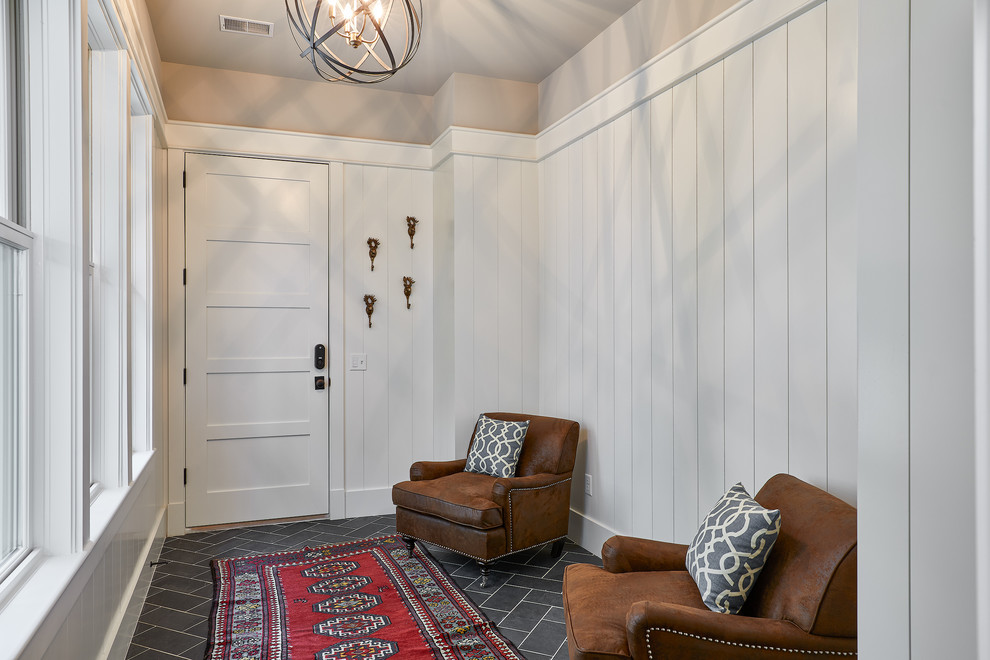 This is an example of a large beach style entryway in Charleston with white walls.