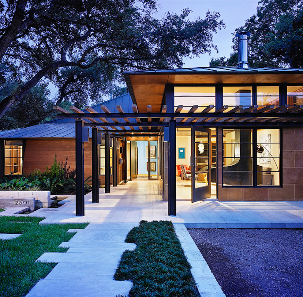This is an example of a large asian two-storey brown house exterior in Austin with wood siding, a hip roof and a metal roof.