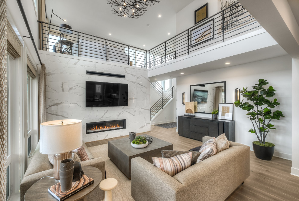 Large contemporary open concept living room in Seattle with white walls, medium hardwood floors, a ribbon fireplace, a tile fireplace surround, a wall-mounted tv and beige floor.