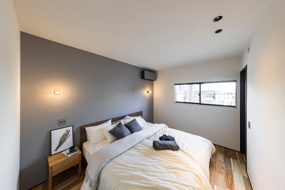 Industrial Hauptschlafzimmer mit grauer Wandfarbe, dunklem Holzboden, braunem Boden, Tapetendecke und Tapetenwänden in Sonstige