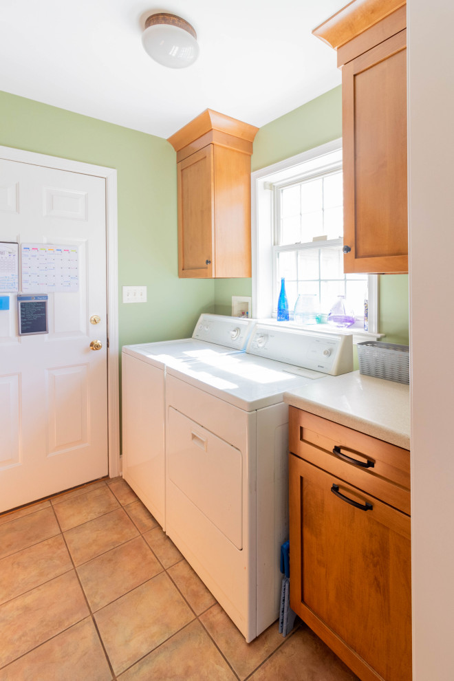 This is an example of a small traditional galley utility room in Other with shaker cabinets, medium wood cabinets, laminate benchtops, green walls, porcelain floors, a side-by-side washer and dryer, beige floor and beige benchtop.