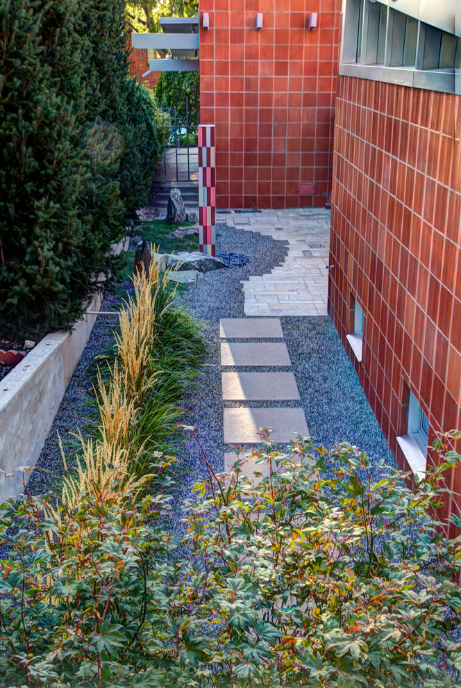 Photo of a mid-sized midcentury side yard partial sun formal garden in Denver with gravel.