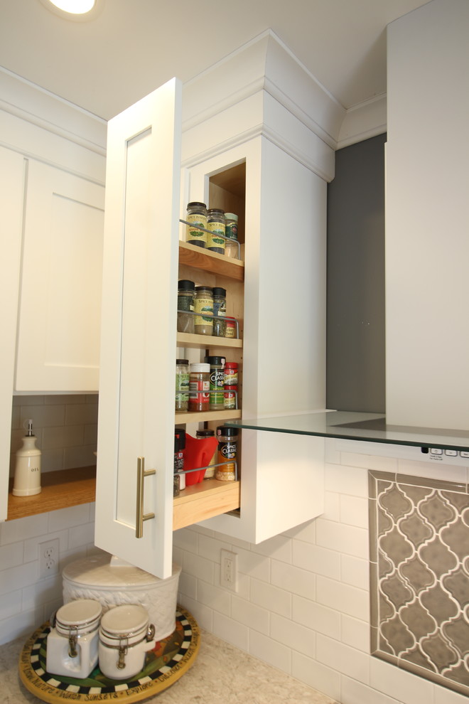 Enclosed kitchen - mid-sized transitional u-shaped medium tone wood floor and brown floor enclosed kitchen idea with a farmhouse sink, shaker cabinets, white cabinets, quartz countertops, white backsplash, subway tile backsplash, white appliances, no island and beige countertops