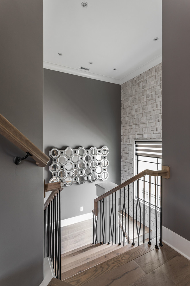 Inspiration for a contemporary wood u-shaped staircase in Indianapolis with metal railing.