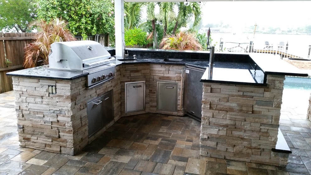 Photo of a mid-sized traditional backyard patio in Tampa with an outdoor kitchen and tile.