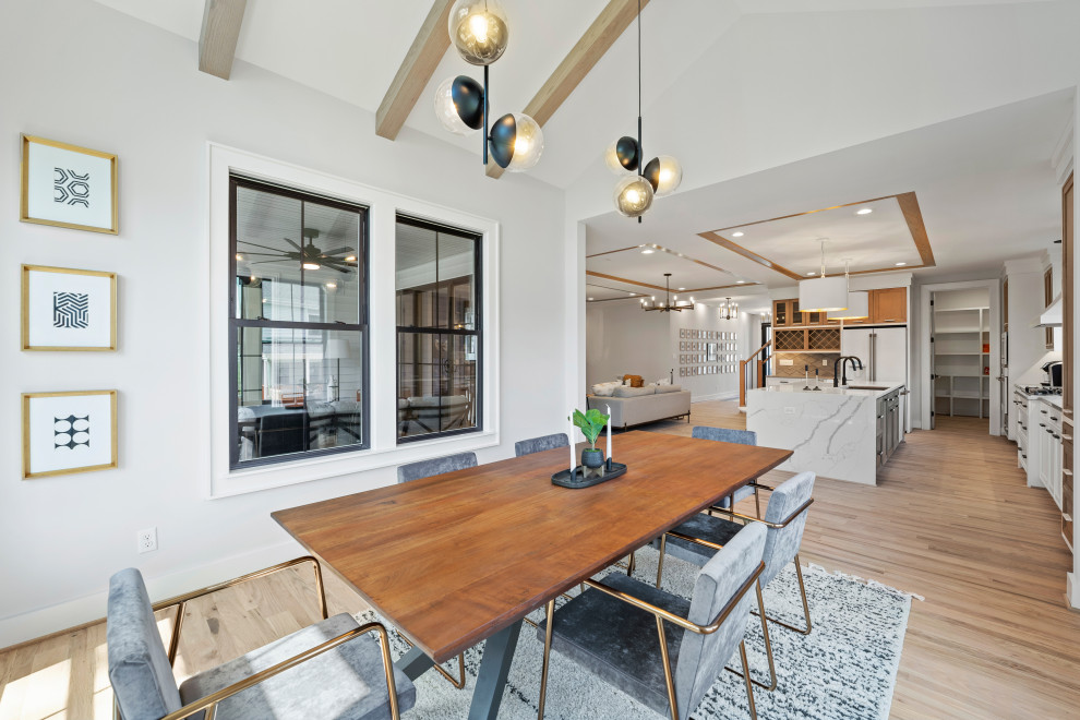 Example of a large trendy light wood floor and vaulted ceiling kitchen/dining room combo design in Richmond with white walls and no fireplace