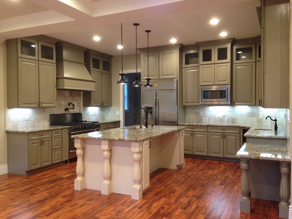 Inspiration for a large traditional u-shaped open plan kitchen in San Francisco with an undermount sink, raised-panel cabinets, green cabinets, granite benchtops, beige splashback, stainless steel appliances, medium hardwood floors, with island, brown floor, travertine splashback and green benchtop.