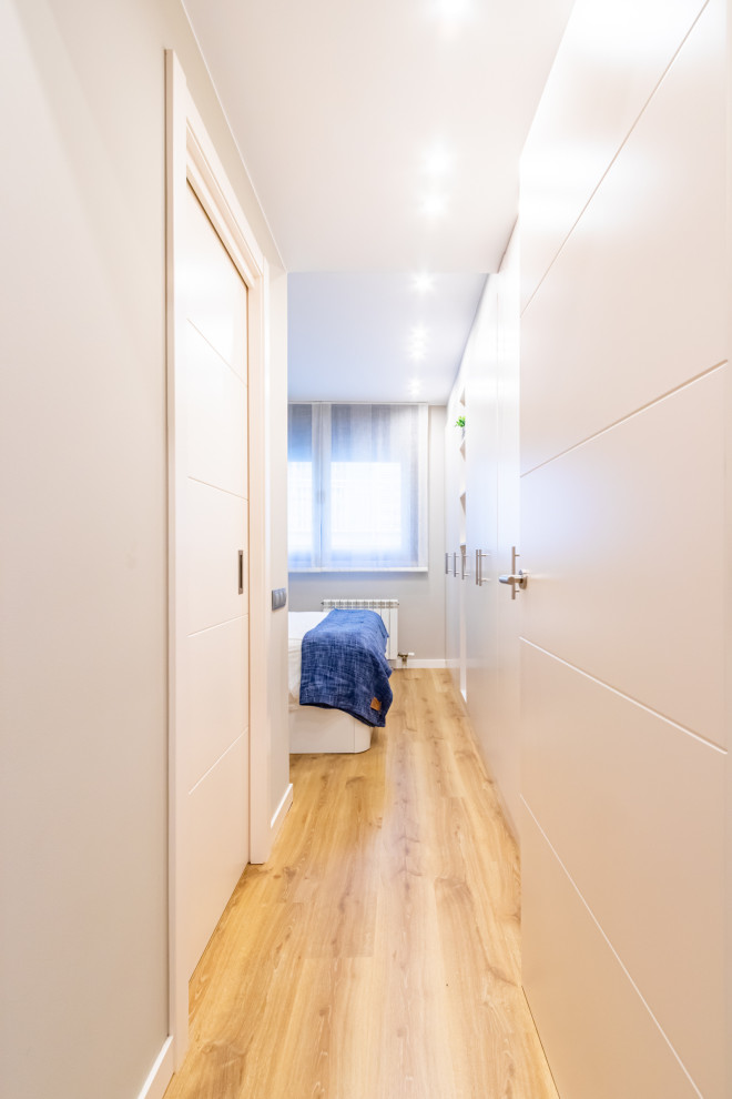 Design ideas for a mid-sized contemporary hallway in Barcelona with beige walls and laminate floors.