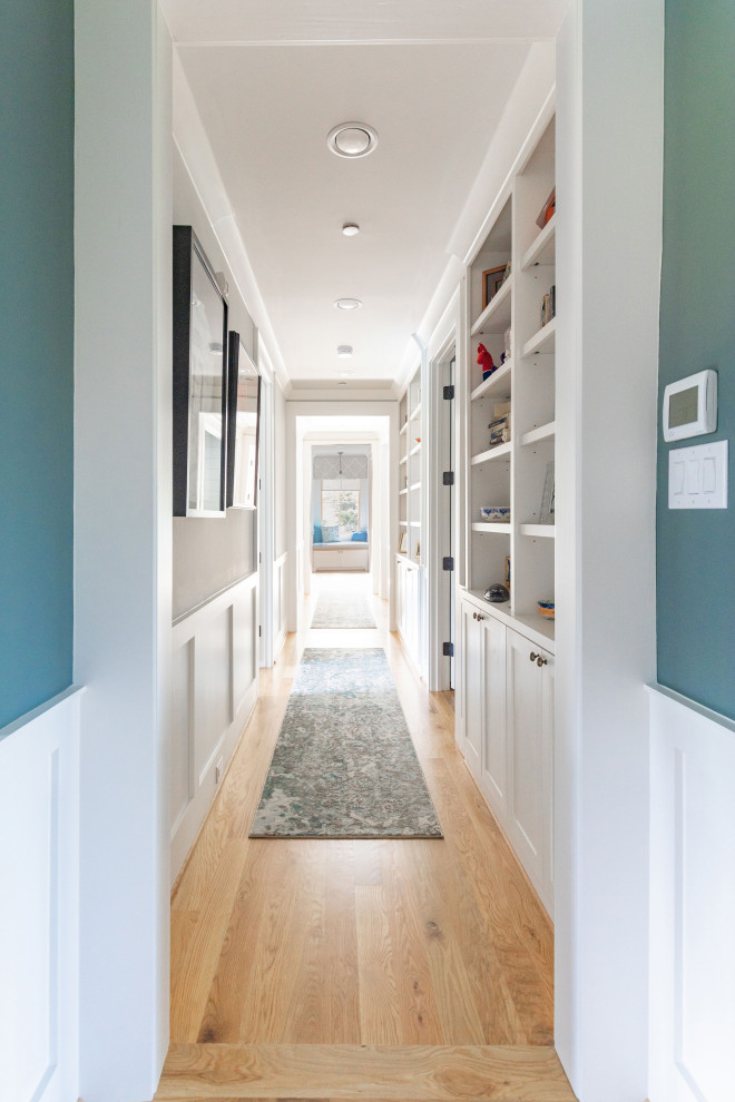 Design ideas for a large country hallway in Houston with blue walls, light hardwood floors and beige floor.