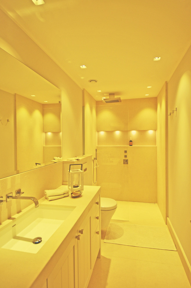 Maritimes Badezimmer mit Kalkstein und integriertem Waschbecken in Sonstige