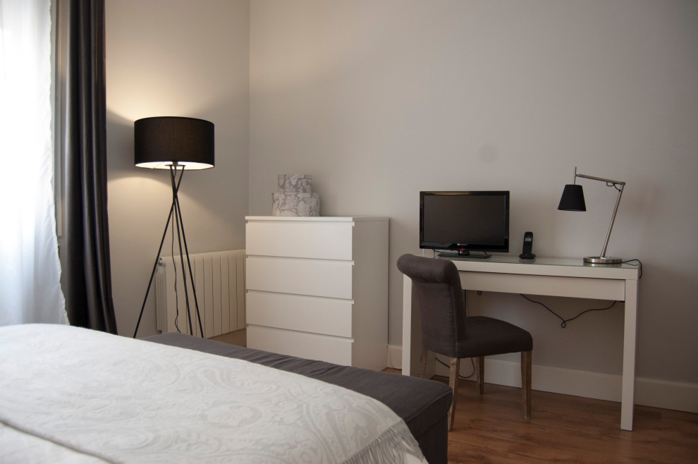 Diseño de dormitorio principal clásico renovado pequeño con paredes grises y suelo de madera en tonos medios