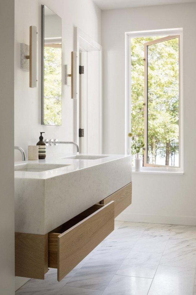 Modern inredning av ett vit vitt en-suite badrum, med släta luckor, skåp i ljust trä, marmorgolv, ett undermonterad handfat och marmorbänkskiva