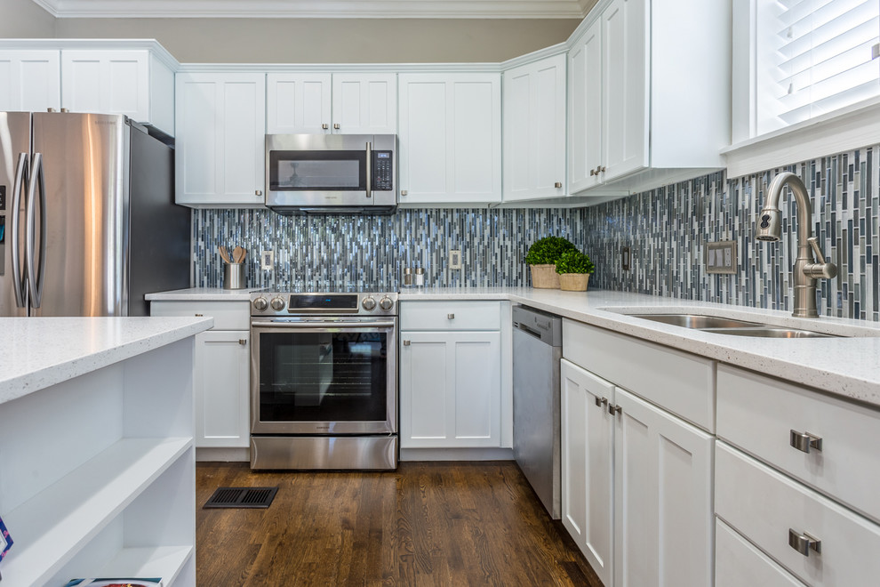 Open concept kitchen - mid-sized transitional l-shaped dark wood floor and brown floor open concept kitchen idea in Miami with shaker cabinets, white cabinets, quartz countertops, multicolored backsplash, mosaic tile backsplash, stainless steel appliances, an island and a double-bowl sink