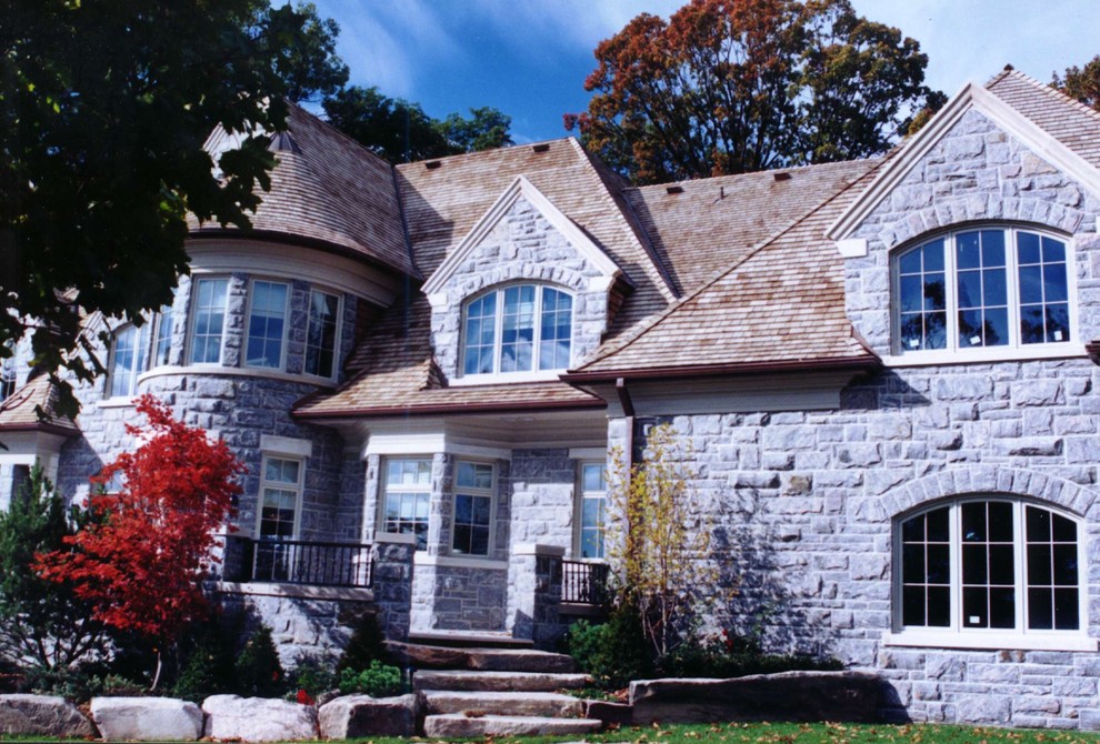 Inspiration for a large traditional two-storey grey exterior in Toronto with stone veneer and a gable roof.