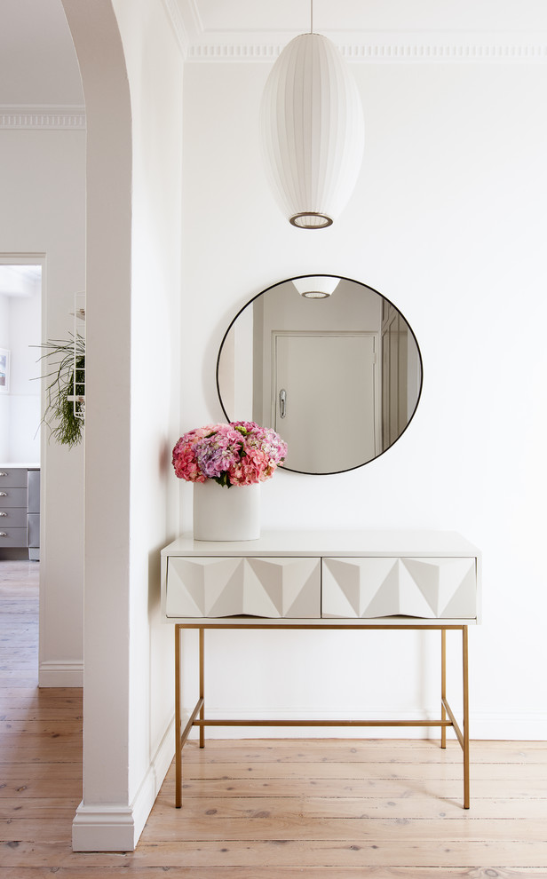 Inspiration for a small eclectic entry hall in Sydney with white walls, light hardwood floors, a single front door, a white front door and white floor.