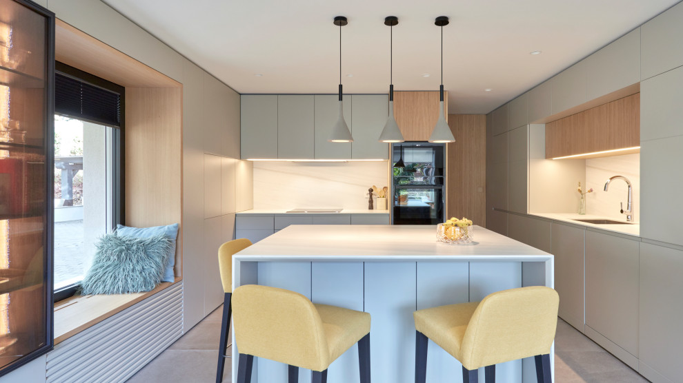 Inspiration for a large contemporary eat-in kitchen in Madrid with an undermount sink, flat-panel cabinets, grey cabinets, white splashback, panelled appliances, porcelain floors, with island, grey floor and white benchtop.