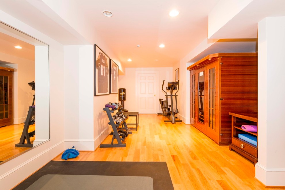 Photo of a large traditional home yoga studio in Boston with white walls, light hardwood floors and yellow floor.
