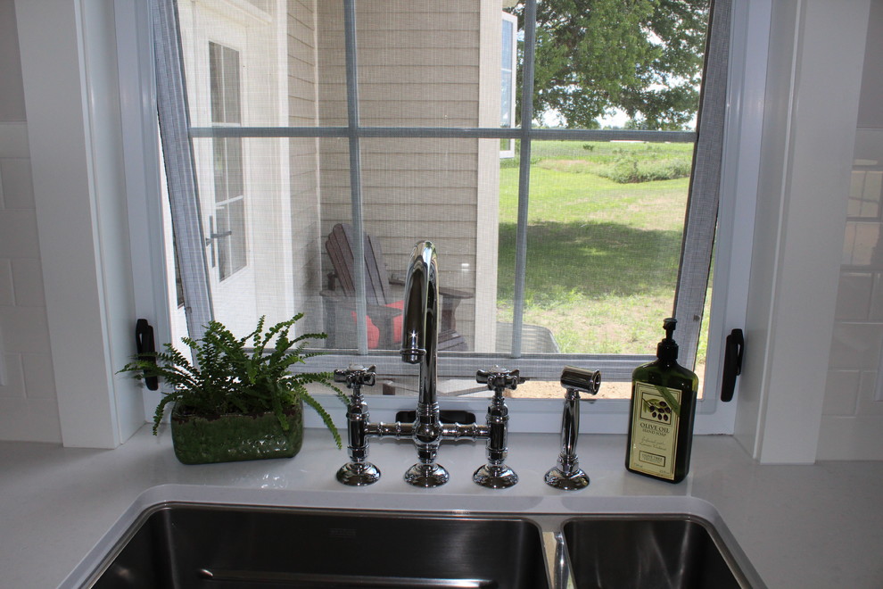 Large transitional l-shaped eat-in kitchen photo in Toronto with an undermount sink, shaker cabinets, white cabinets, quartz countertops, white backsplash, stainless steel appliances and an island