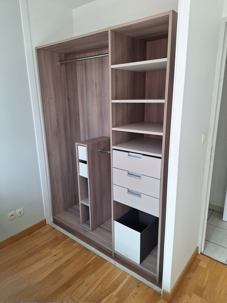 Photo of a mid-sized transitional built-in wardrobe in Lyon with beaded inset cabinets and medium wood cabinets.