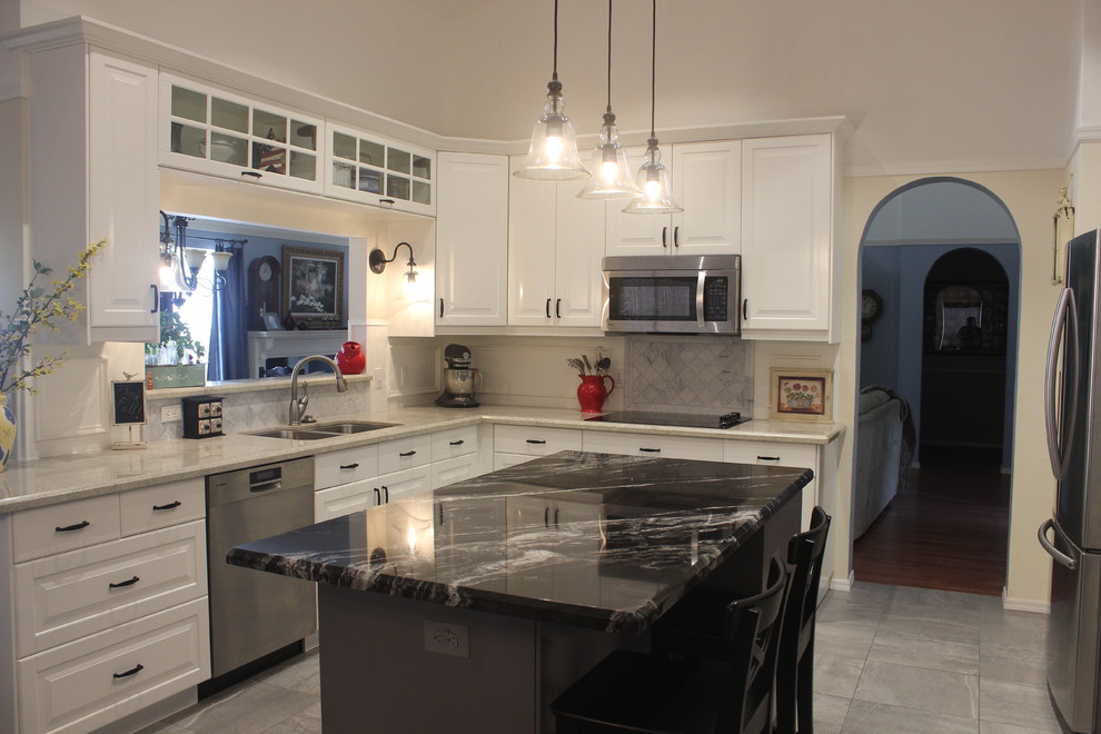 Mid-sized transitional u-shaped ceramic tile enclosed kitchen photo in Phoenix with a double-bowl sink, raised-panel cabinets, white cabinets, marble countertops, gray backsplash, ceramic backsplash, stainless steel appliances and an island