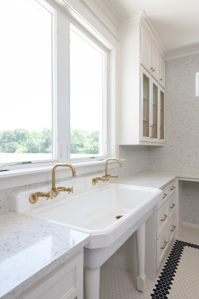 Expansive country u-shaped dedicated laundry room in Dallas with a farmhouse sink, shaker cabinets, white cabinets, quartz benchtops, beige splashback, mosaic tile splashback, white walls, ceramic floors, a side-by-side washer and dryer, multi-coloured floor and multi-coloured benchtop.