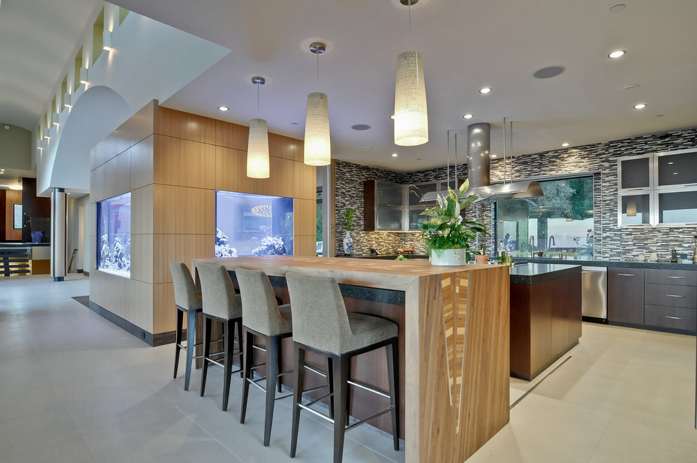 This is an example of a contemporary kitchen in San Francisco with flat-panel cabinets, dark wood cabinets, multi-coloured splashback, matchstick tile splashback and stainless steel appliances.