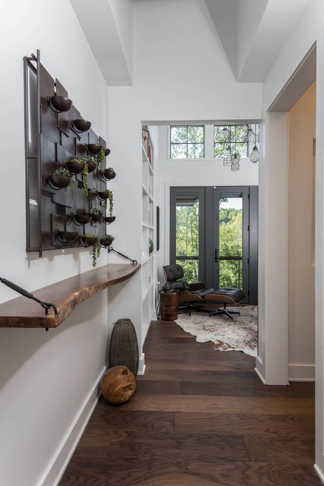 Photo of a mid-sized country hallway in Other with white walls and dark hardwood floors.