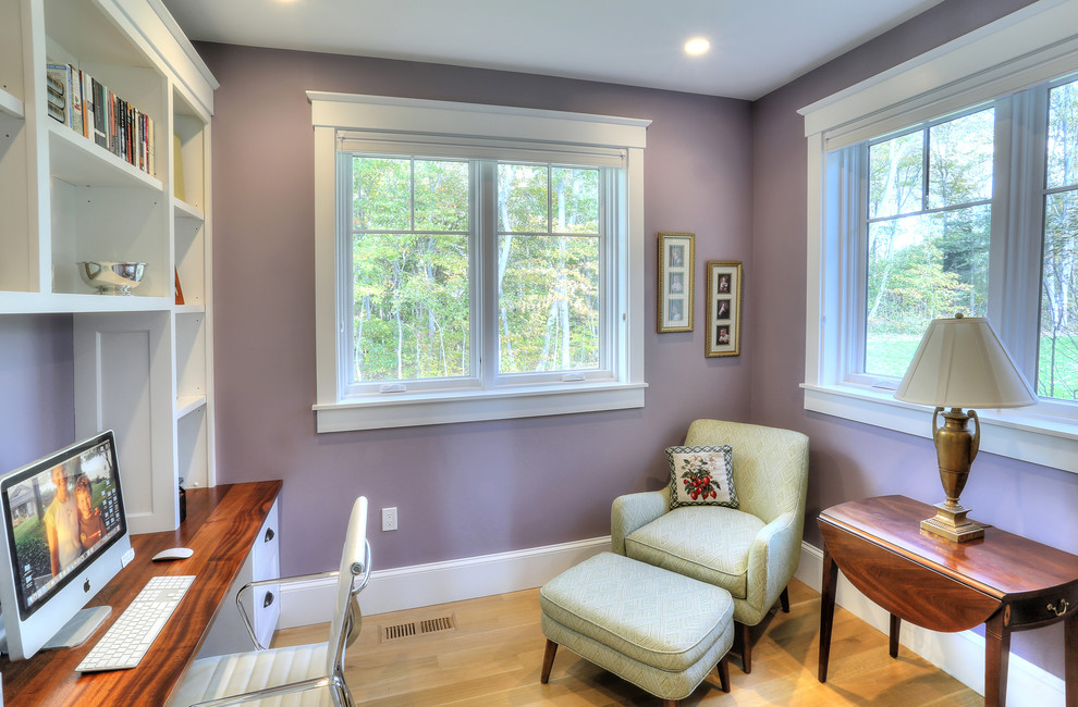 Large beach style home office in Bridgeport with purple walls, light hardwood floors and a built-in desk.