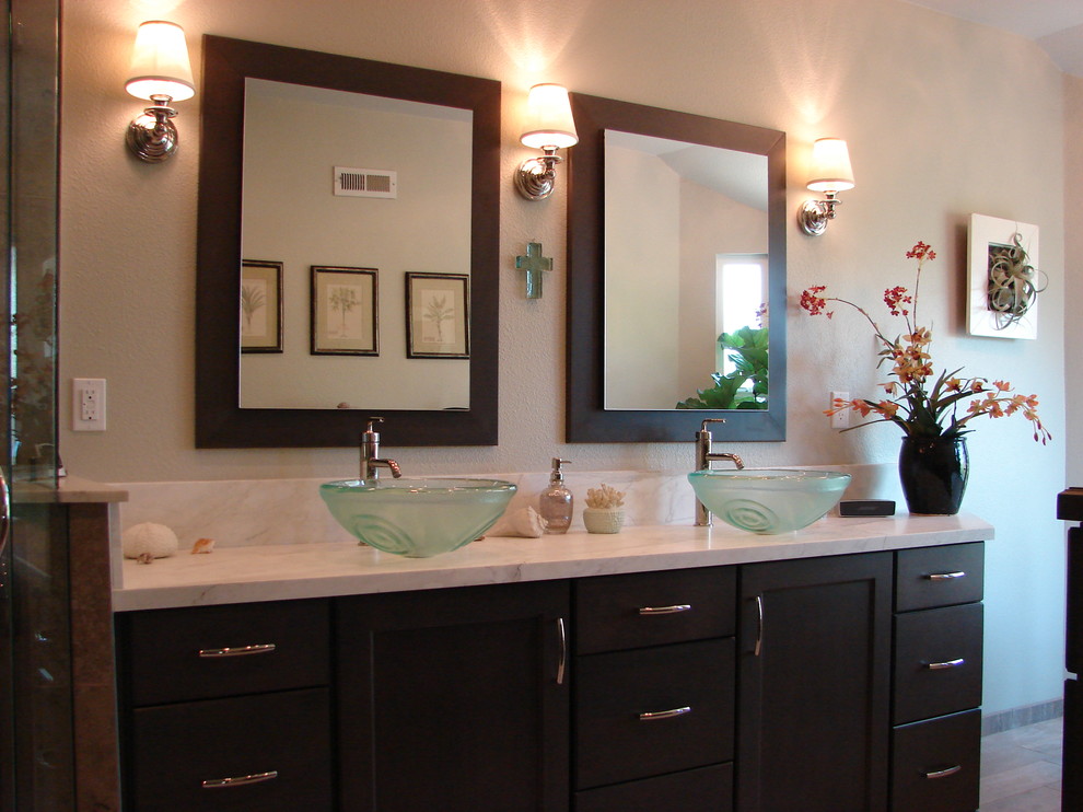 Design ideas for a large transitional master bathroom in Orange County with a vessel sink, shaker cabinets, dark wood cabinets, marble benchtops, a freestanding tub, a corner shower, a two-piece toilet, gray tile, stone tile and porcelain floors.