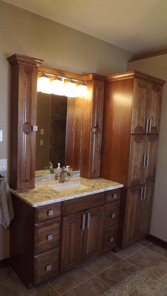 Transitional beige tile and porcelain tile porcelain tile doorless shower photo with an undermount sink, raised-panel cabinets, medium tone wood cabinets, granite countertops and beige walls