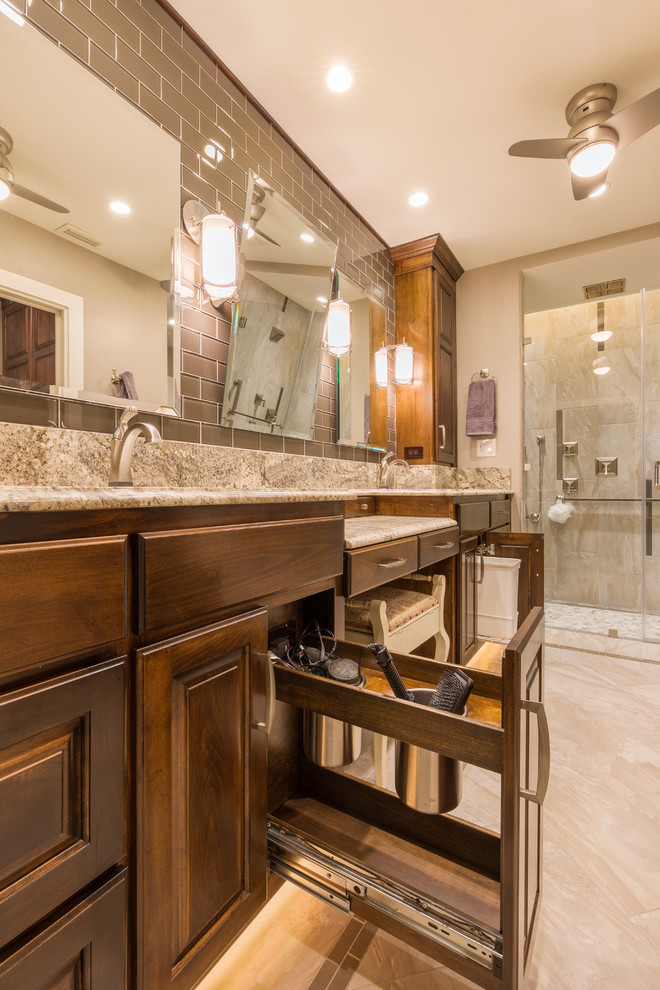 Mid-sized traditional master bathroom in Austin with an undermount sink, raised-panel cabinets, medium wood cabinets, granite benchtops, a curbless shower, gray tile, glass tile, beige walls and porcelain floors.