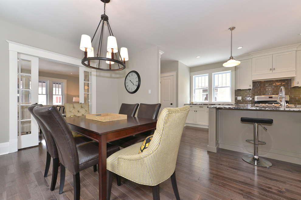 This is an example of a mid-sized transitional kitchen/dining combo in Toronto with grey walls, medium hardwood floors, no fireplace and brown floor.