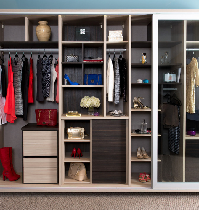 Inspiration for a large contemporary women's built-in wardrobe in Seattle with glass-front cabinets and carpet.