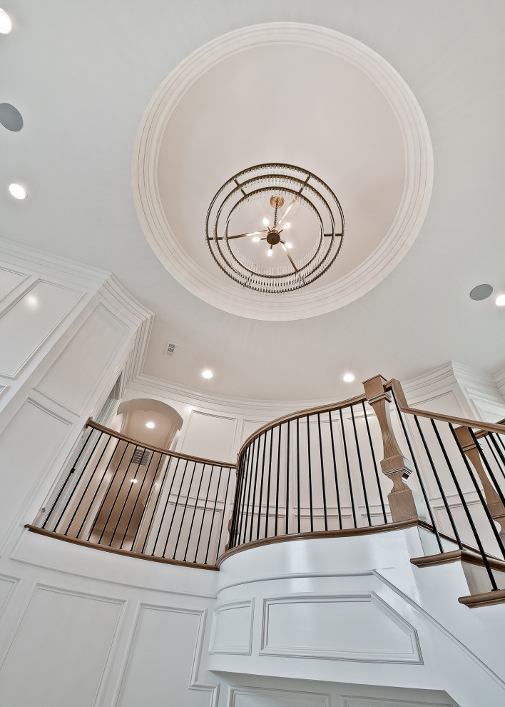 Design ideas for a large traditional wood curved wood railing staircase in Other with wood risers and panelled walls.