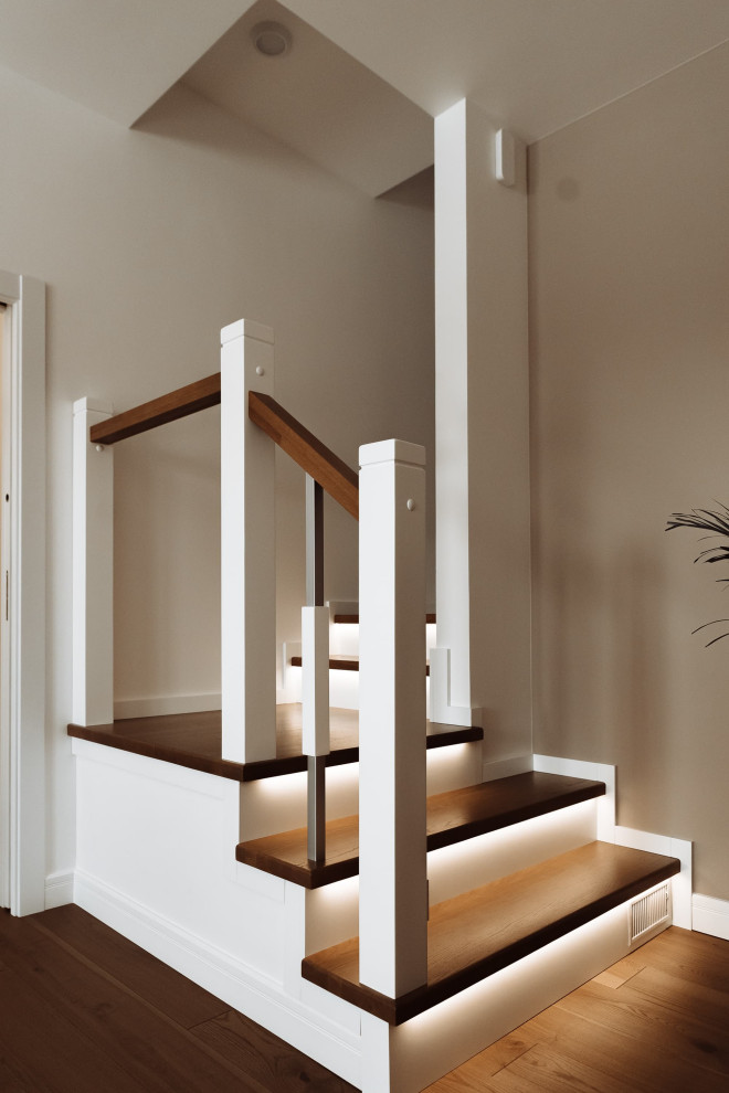 Ejemplo de escalera curva contemporánea grande con escalones de madera, contrahuellas de madera, barandilla de metal y ladrillo