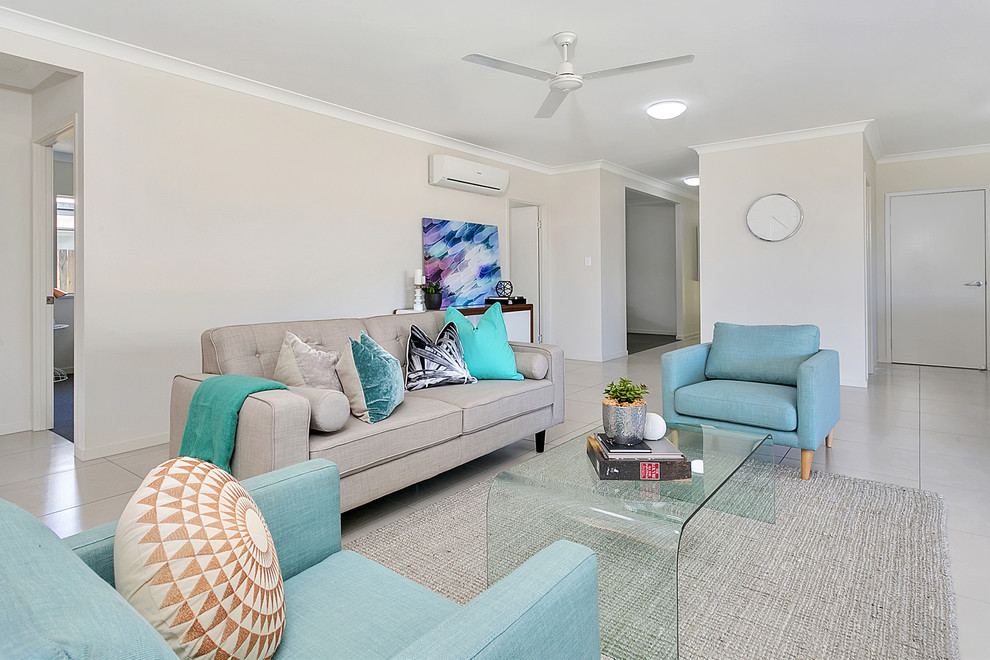 Photo of a beach style formal enclosed living room in Cairns with beige walls and grey floor.