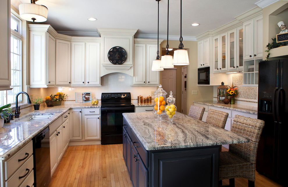 Inspiration for a transitional enclosed kitchen remodel in St Louis with an undermount sink, raised-panel cabinets, white cabinets, granite countertops, subway tile backsplash and black appliances