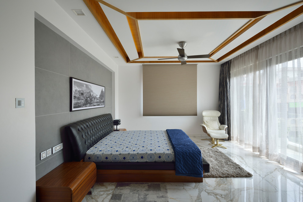 This is an example of a contemporary bedroom in Delhi with white walls, marble floors and white floor.