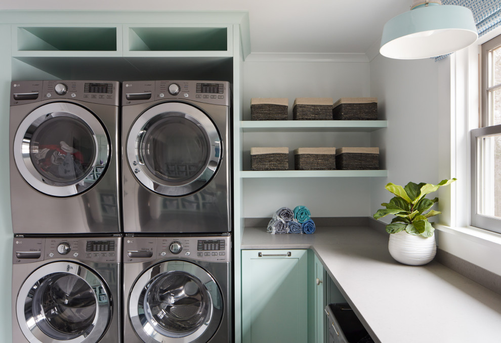 Design ideas for a large transitional u-shaped dedicated laundry room in Boston with an undermount sink, turquoise cabinets, quartz benchtops, white walls, ceramic floors, a stacked washer and dryer, grey floor and grey benchtop.