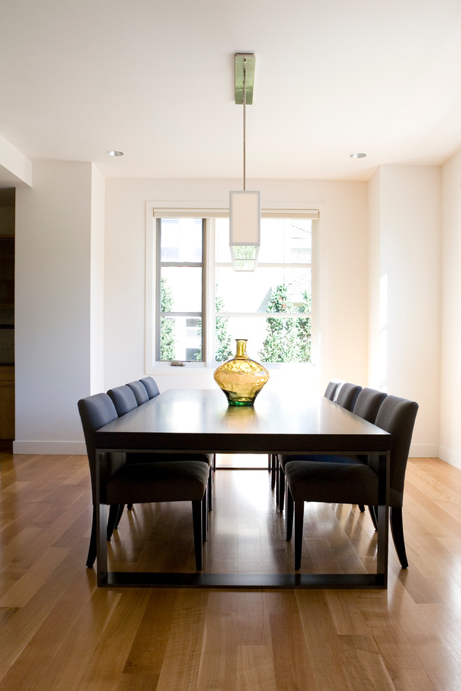 This is an example of a contemporary dining room in Boise with white walls and medium hardwood floors.