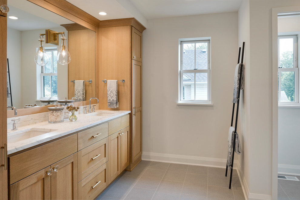 Inspiration for a mid-sized transitional master bathroom in Minneapolis with shaker cabinets, light wood cabinets, white walls, ceramic floors, an undermount sink, marble benchtops, grey floor and white benchtops.