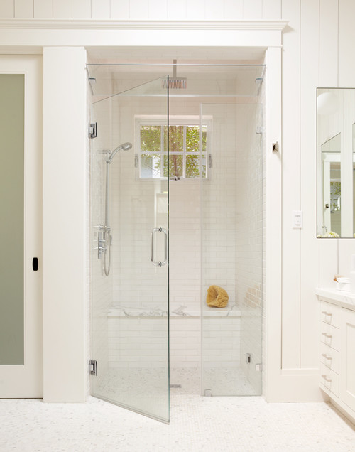 Large white tile shower with bench, steam shower, and window for natural light