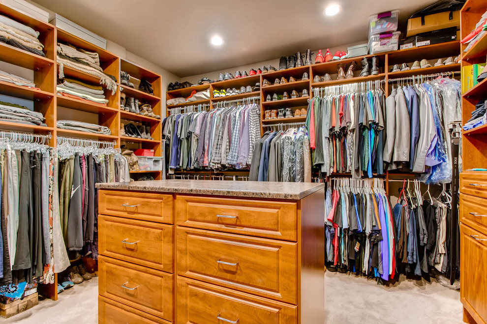 Photo of a large traditional gender-neutral walk-in wardrobe in Denver with raised-panel cabinets, medium wood cabinets, carpet and beige floor.
