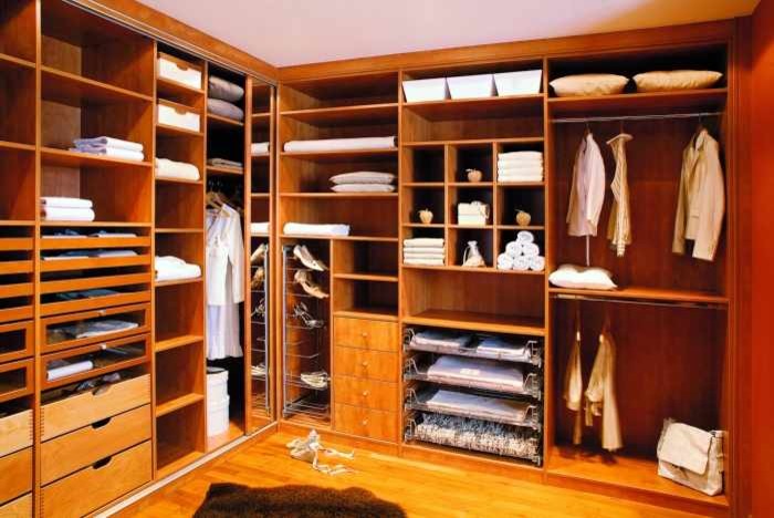 Photo of a mid-sized transitional gender-neutral walk-in wardrobe in Miami with open cabinets, medium wood cabinets and medium hardwood floors.