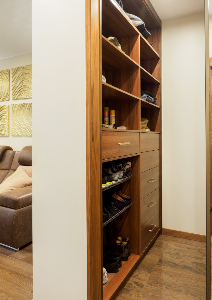 Immagine di una piccola cabina armadio unisex con pavimento in gres porcellanato e pavimento marrone