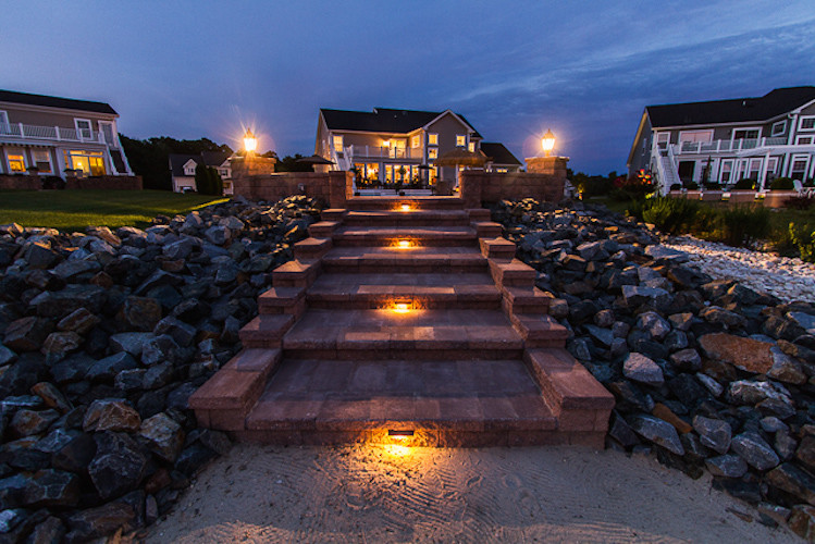 Inspiration for a large partial sun backyard stone landscaping.