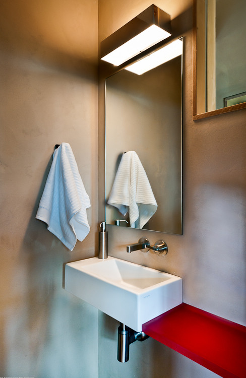 This is an example of a small contemporary 3/4 bathroom in Denver with solid surface benchtops and a wall-mount sink.